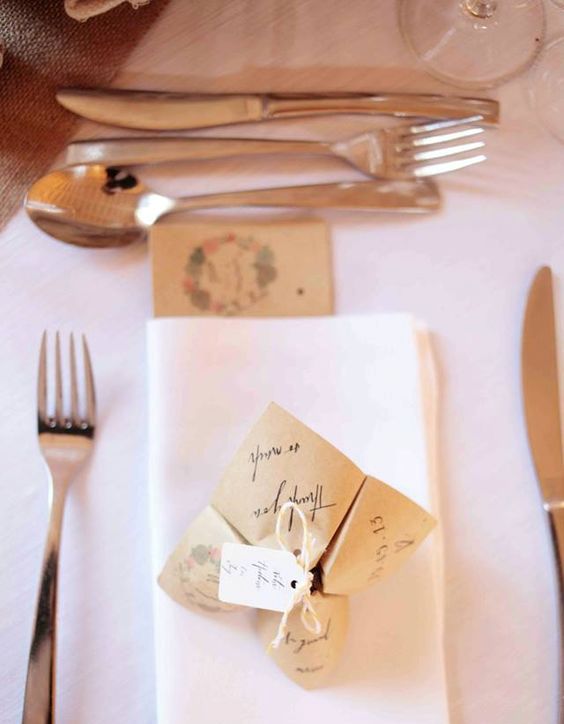 a origami wedding proglam or menu made of craft paper and with a tag and yarn for a rustic wedding