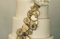17 a wedding cake topped with edible gold coins and a sugar flower