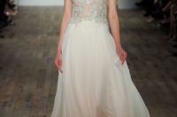 18 a creamy wedding gown on straps with a lace applique embellished bodice and a flowy skirt by Lazaro