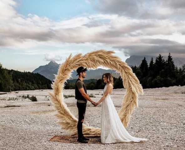 a pampas grass circle floral wedding arch for an ocean wedding