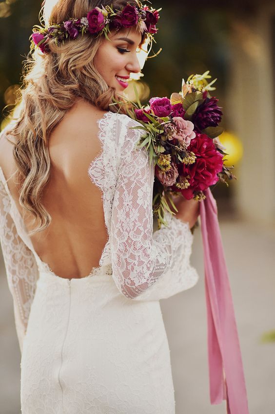 a lace sheath bell sleeve wedding dress with an open back for a boho bride