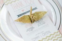 19 a place setting in blush and gold glitter with a glitter paper crane and a lace edge charger