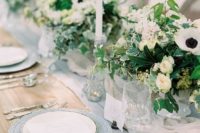 19 a stunning wedding tablescape with a blue runner and chargers, white floral centerpieces and plates