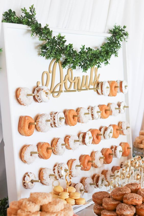 a fresh boxwood garland and calligraphy letters for highlighting the donut wall