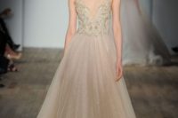 20 champagne-colored illusion plunging neckline wedding dress with an embellished bodice and a sparkly skirt by Lazaro