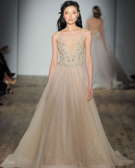 champagne-colored illusion plunging neckline wedding dress with an embellished bodice and a sparkly skirt by Lazaro