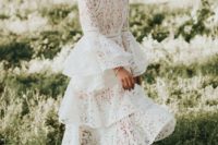 21 a lace wedding dress with a high neckline, bell sleeves and a layered skirt to stand out