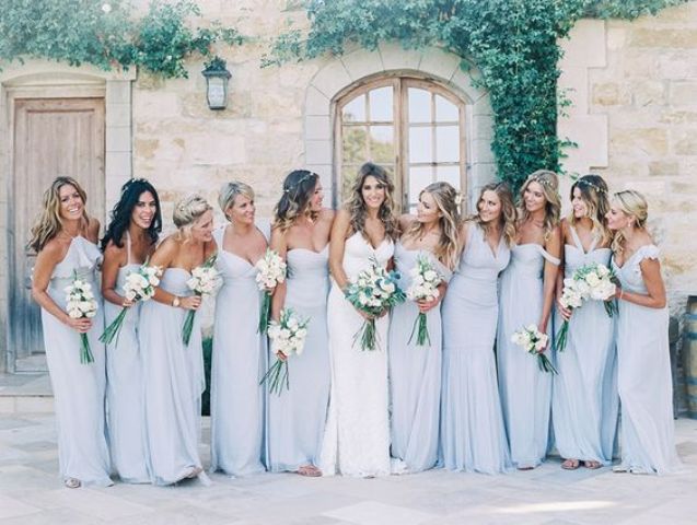 bridesmaids wearing baby blue dresses and carrying white bouquets