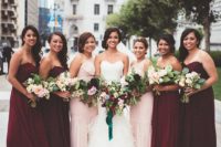 22 bridesmaids wearing strapless marsala gowns and one shoulder blush ones