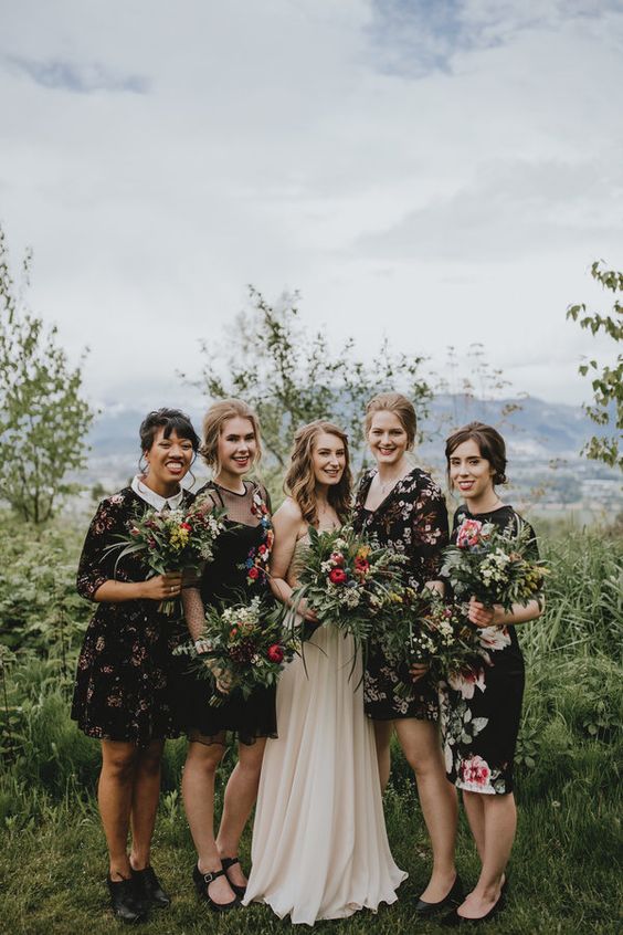 mismatching dark floral bridesmaids' dresses of various lengths and looks