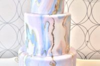 23 a marbleized pink and blue wedding cake with gold leaf touches