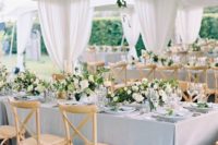 23 an elegant light blue and creamy wedding tent with neutral blooms and blue textiles