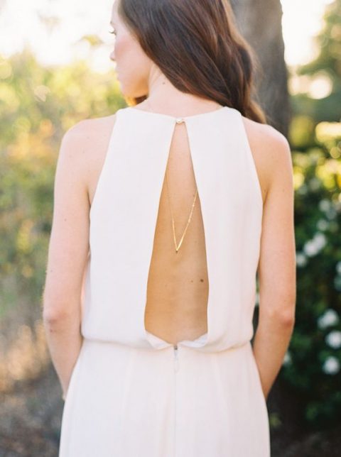 modern wedding gown with a cutout back on a pearl button and a back necklace