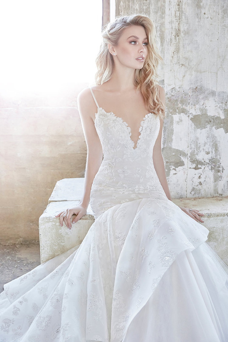 A mermaid wedding gown with spaghetti straps, a lace plunging neckline, lace appliques and embellishments by Hayley Paige