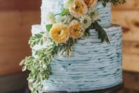 25 light blue layered cake with yellow to orange blooms and greenery