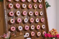 26 a mini donut wall decorated with fresh greenery and with fresh blooms around