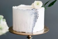 27 a blue edged watercolor cake with a small white bloom on top looks like a masterpiece