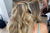 a beautiful and romantic half updo with a twisted elements and waves down is a cool idea for many styles