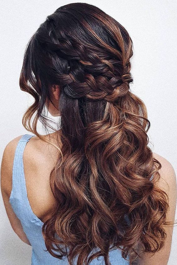 a beautiful boho half updo with a double braided halo and waves down, waves framing the face and caramel balayage that makes it cooler