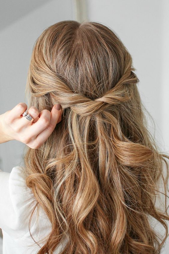 a beautiful half updo with a twisted braid and waves down is a cool idea for a boho braid or bridesmaid