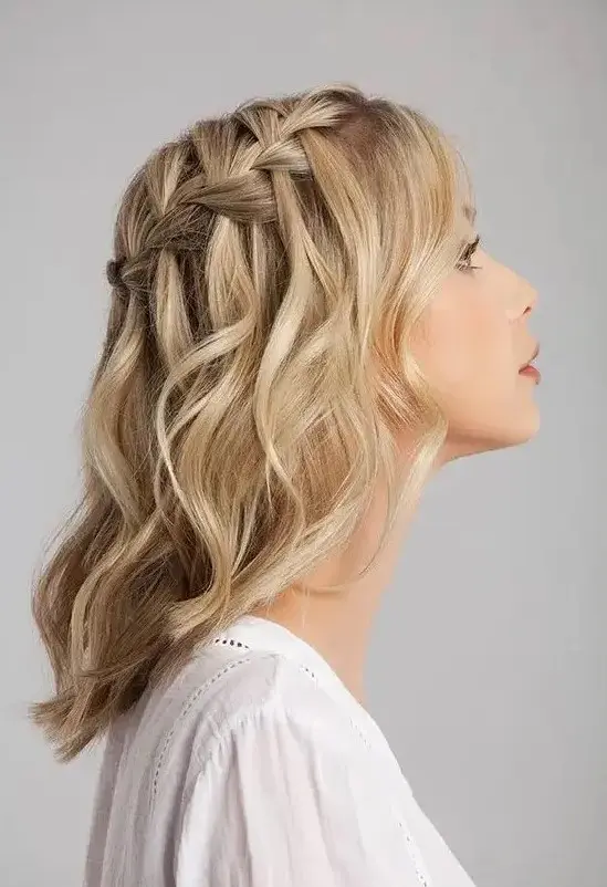 a blonde medium length half updo with a braided top and waves down is a stylish boho wedding idea