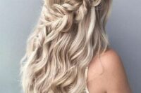 a boho half updo with large loose braids on both sides of the head and waves down is a lovely idea for a wedding