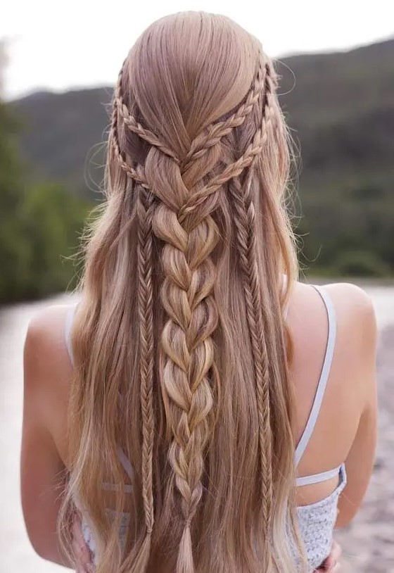 a braided half updo with several small and large braids down and long hair down is a chic and cool idea for a boho bride or bridesmaid