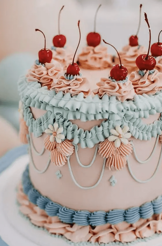 a bright and cool lambeth wedding cake in blush, aqua, light blue and topped with cherries is a fun and cool idea for a spring or summer wedding