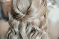 a chic blonde half updo with a twisted element, a bump and waves down is a catchy idea for many styles