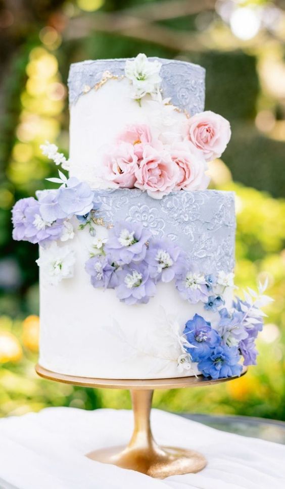a chic wedding cake with lilac and white tiers, gold touches and lilac and blush blooms is wow