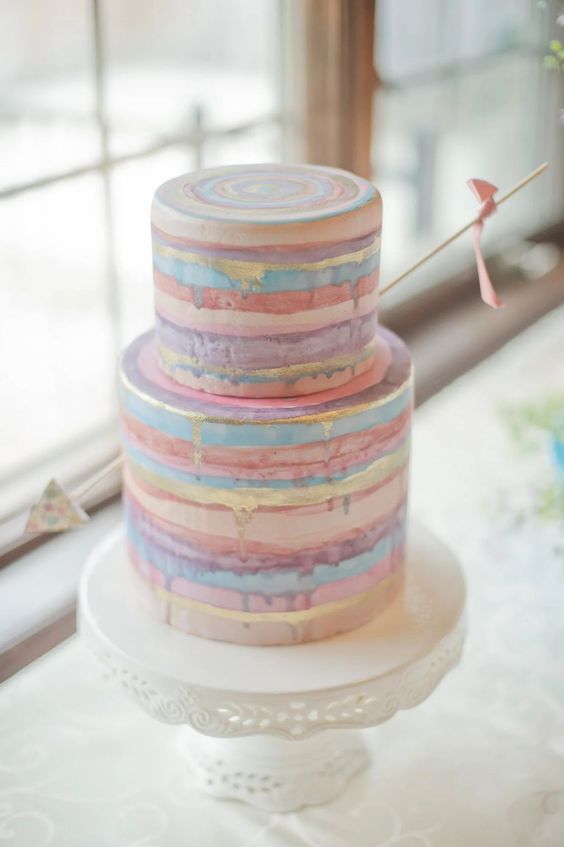 a cool pastel stripe wedding cake decorated with a single arrow is a lovely idea for Valentine's Day
