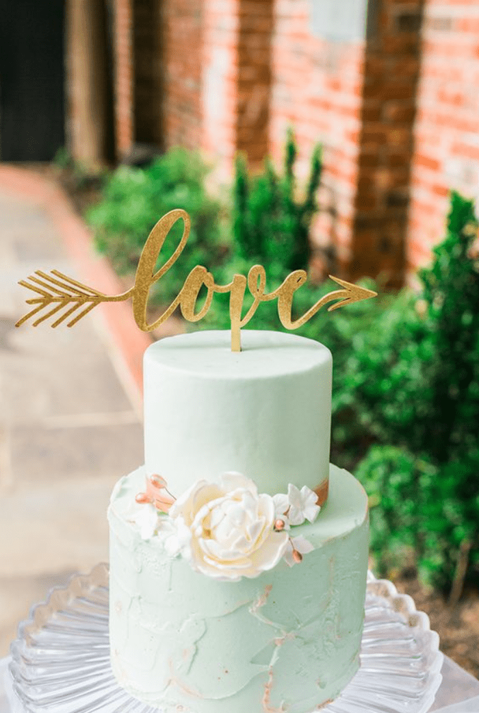 a creative mint wedding cake with a sleek and textural tier, sugar blooms and a glitter calligraphy topper