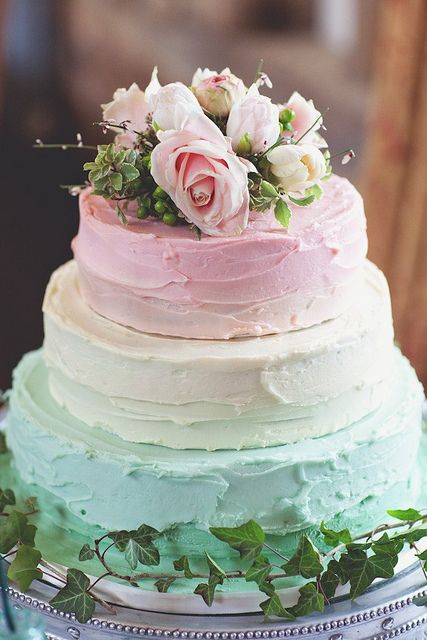 a creative pastel wedding cake with a pink, vanilla and mint tier and some blush roses on top is wow