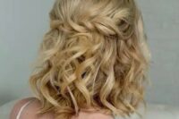 a curly half updo with a twisted braid and curls down plus a peachy crystal crown are a cool combo