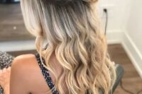 a cute half updo with a volume on top, a top bun and waves down including those framing the face