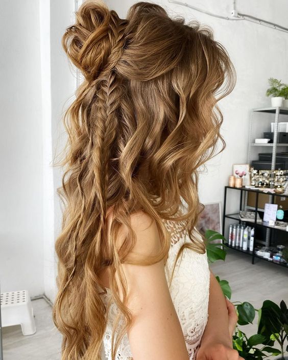 a gorgeous boho half updo with a bump on top, a wrapped top knot, some braids and waves down