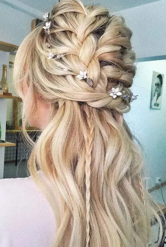 A half updo with a braided top, waves down and small braids down plus face framing locks for a boho bride