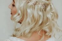 a half updo with a halo braid and waves accented with a hair vine for a boho bride or bridesmaid