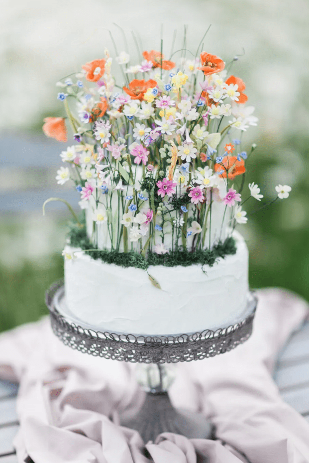 a light green wedding cake decorated with lots of bright spring blooms is a fantastic idea to try