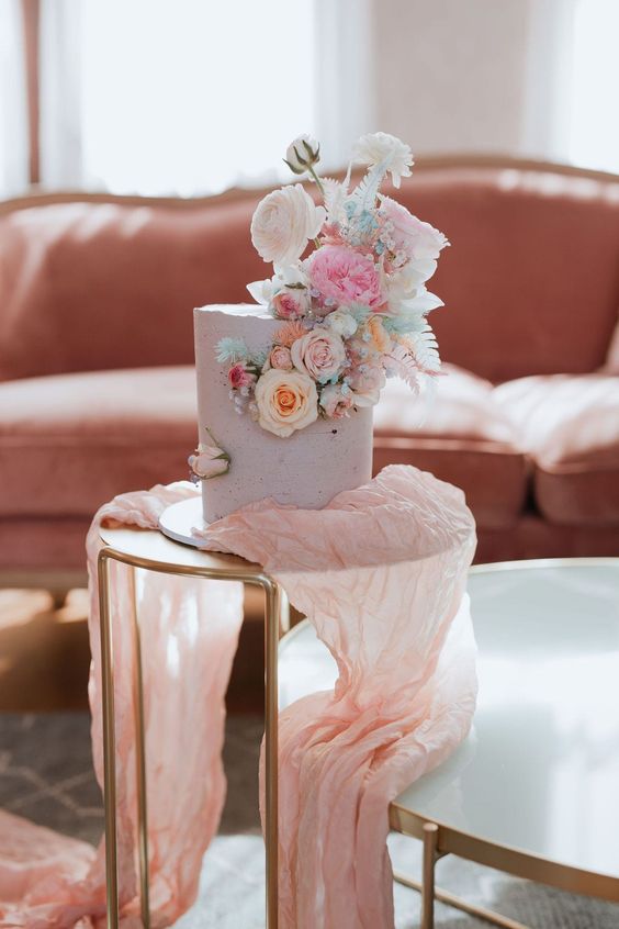 a lilac wedding cake topped with pastel blooms and turquoise touches is a lovely idea for spring or summer