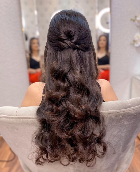 a lovely dark brunette half updo with a sleek top, twists and waves down is a cool idea for a wedding