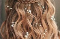 a lovely half updo with a braided halo, waves down and some baby’s breath tucked into the hair is idea for summer