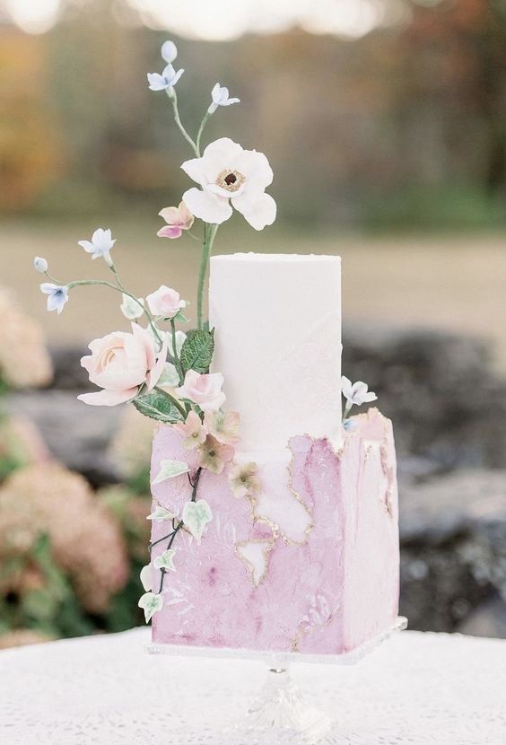 a lovely spring wedding cake with a white and pastel pink tier and some delicate blooms is a chic and cool idea