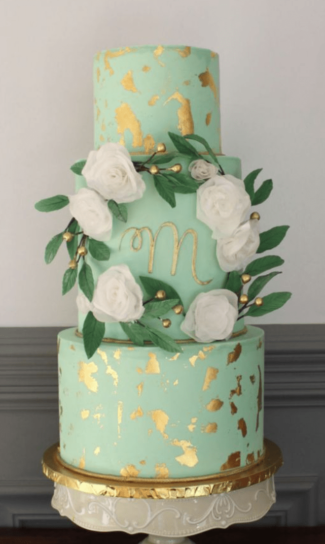 a mint wedding cake with gold leaf, white blooms and berries for decorating will match a spring or summer wedding