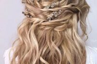 a pretty wavy twisted half updo with waves, fresh blooms and waves down and a bump is a cool rustic or boho solution
