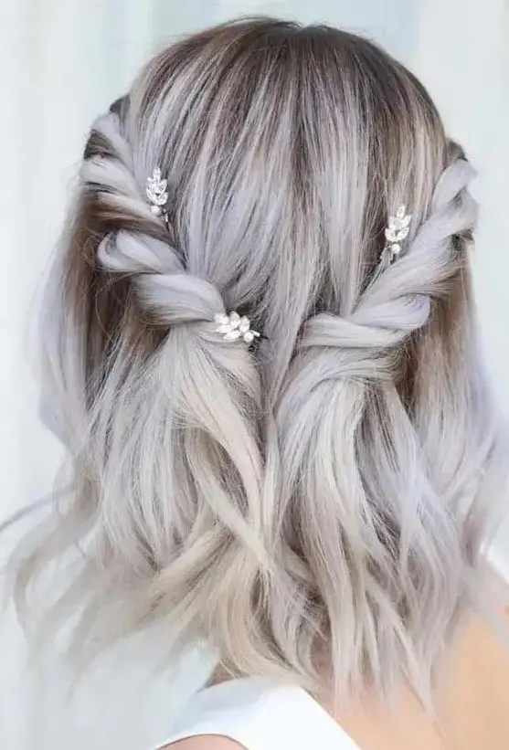 a romantic grey medium half up hairstyle with twisted braids, a darker root for an accent and some waves