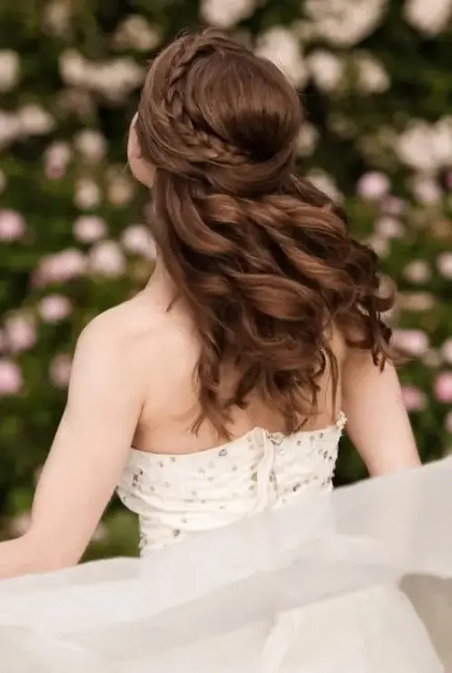 a romantic half updo with a braid on one side and a twist on the second side, with waves down