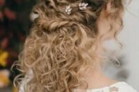 a romantic wedding half updo for naturally curly hair – multiple twists accented with rhinestone hair pins and natural curls down