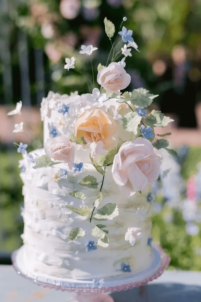 a ruffle wedding cake with pastel blooms and greenery is a cool idea for a deliccate spring wedding