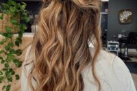 a textured boho half updo with a messy wavy top, a ponytail with a wrapped touch and waves down is amazing